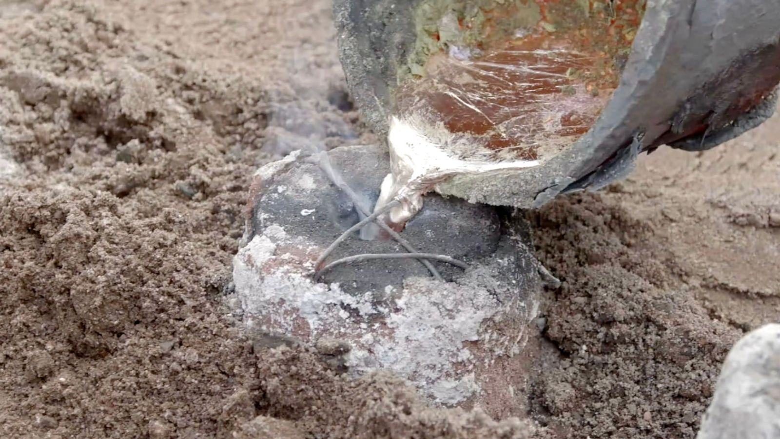 When the clay mold is fired, the wax flows out, leaving a cavity – the negative mold. This mold is buried in the ground and filled with molten metal.